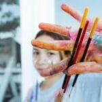 Jak dobrać pędzle do gwaszu: okrągłe, płaskie i wachlarzowe w codziennym użyciu Pomalowane ręce trzymające różne pędzle do malowania gwaszem