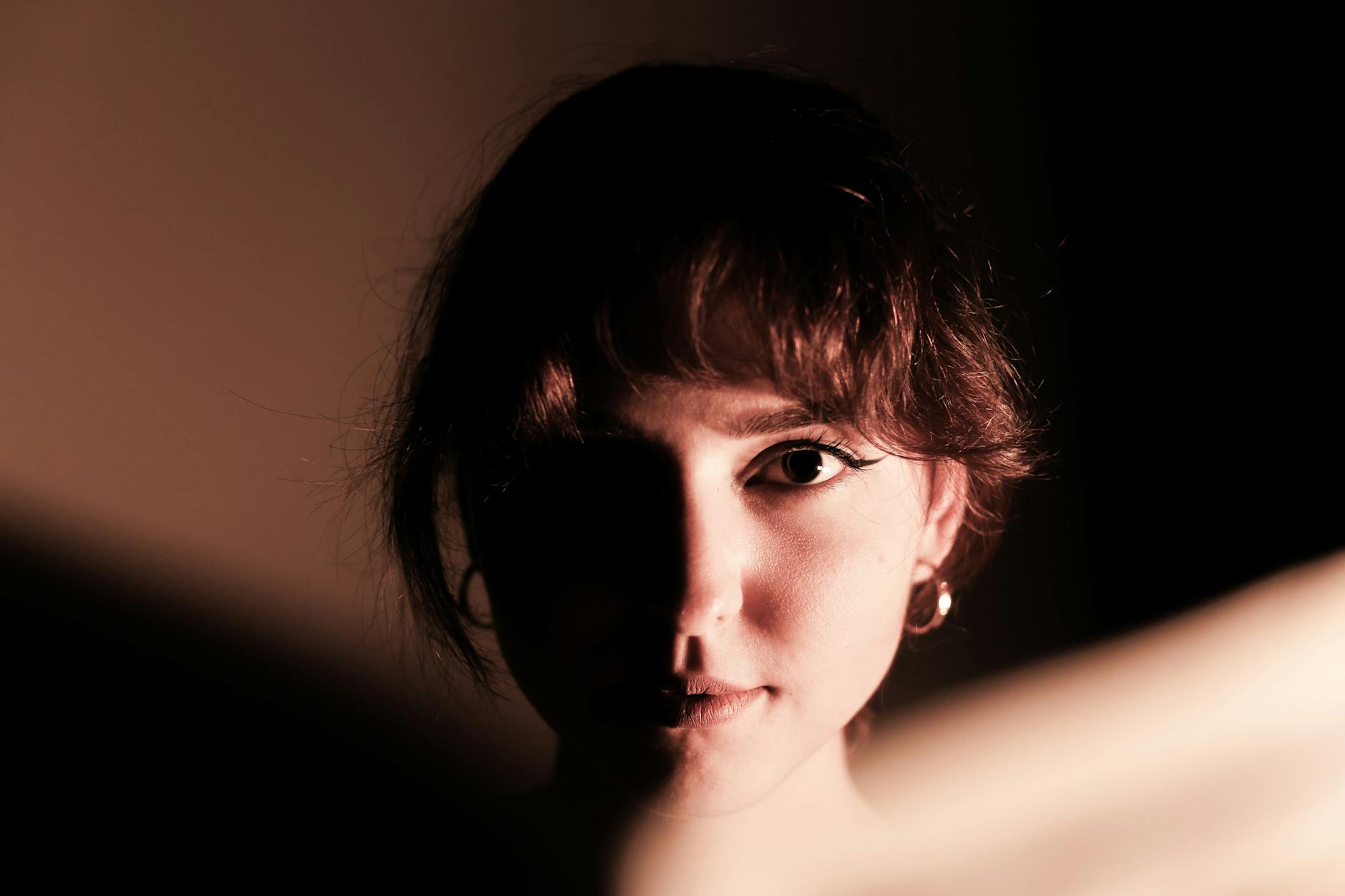 Portret kobiety w ostrym świetle bocznym z wyraźnymi cieniami na twarzy